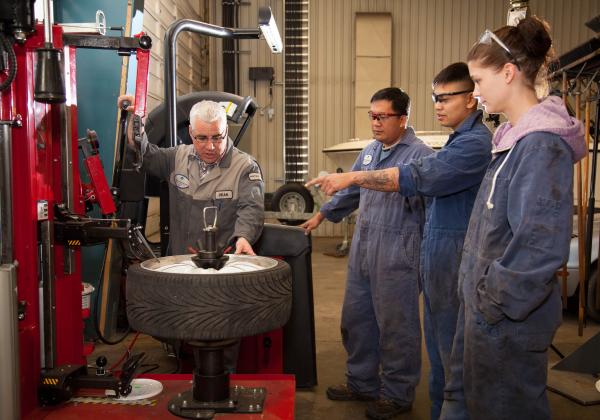 An instructor of the Automotive Service Technician program explaining a tool to students