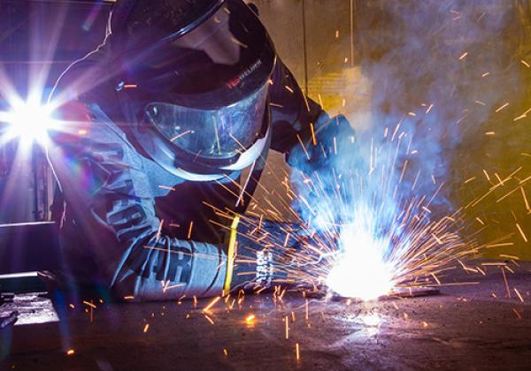 A welder at work, creating sparks while working on a car