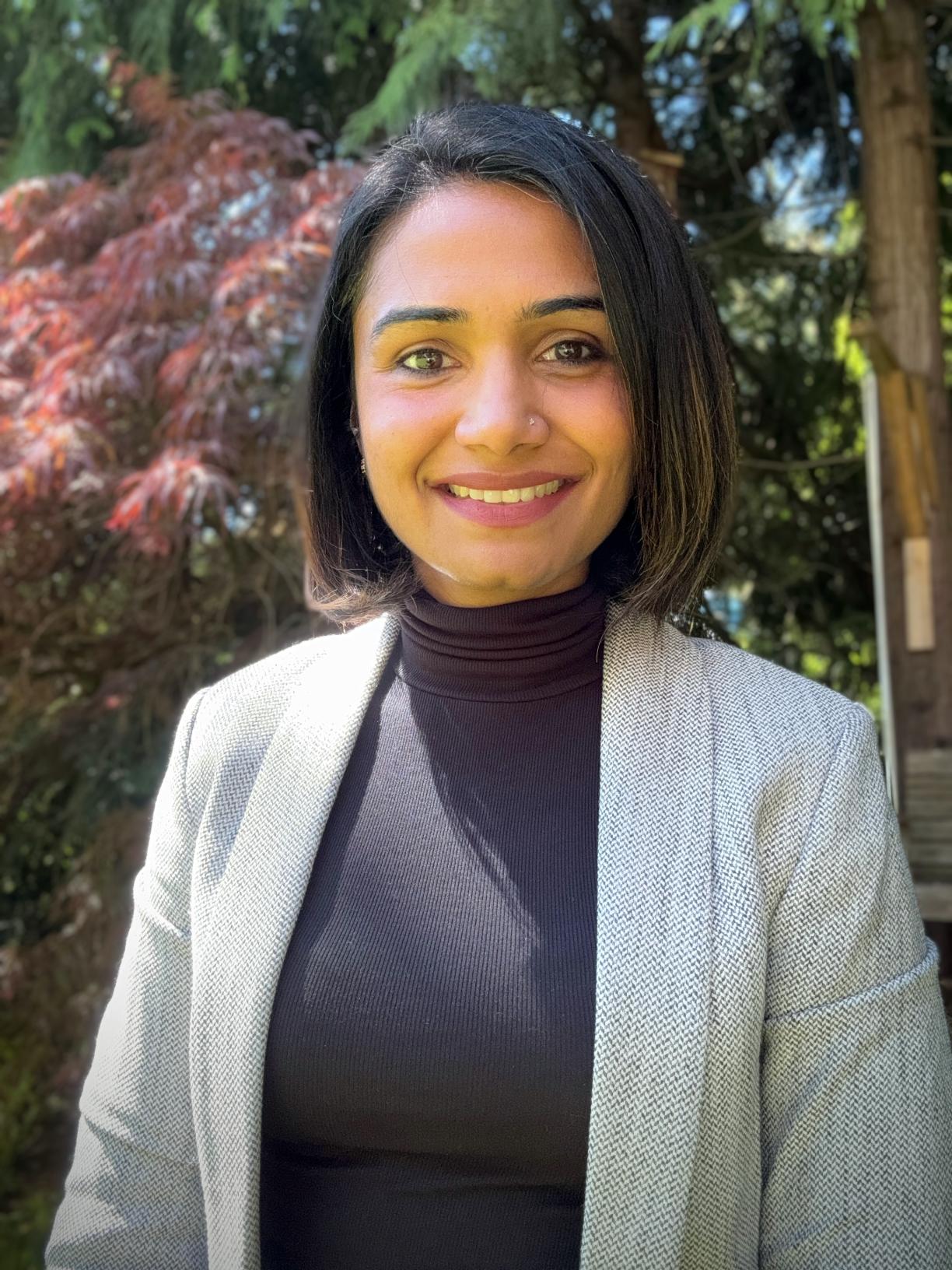 A smiling woman wearing a blazer. 